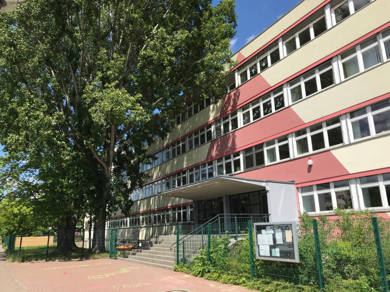 Der Schuleingang an der Vorderseite des Gebäudes an einem sonnigen Sommertag.