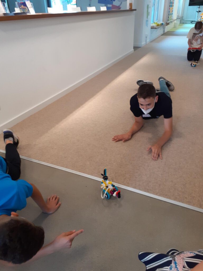 zwei Jungs spielen mit einem Roboter