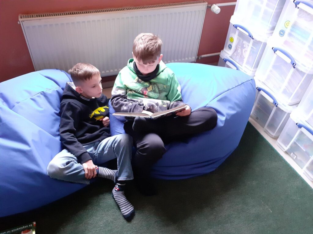 Zwei Kinder lesend auf einem Sitzsack