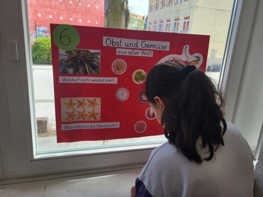Ein Kind steht vor einem Plakat über gesundes Essen
