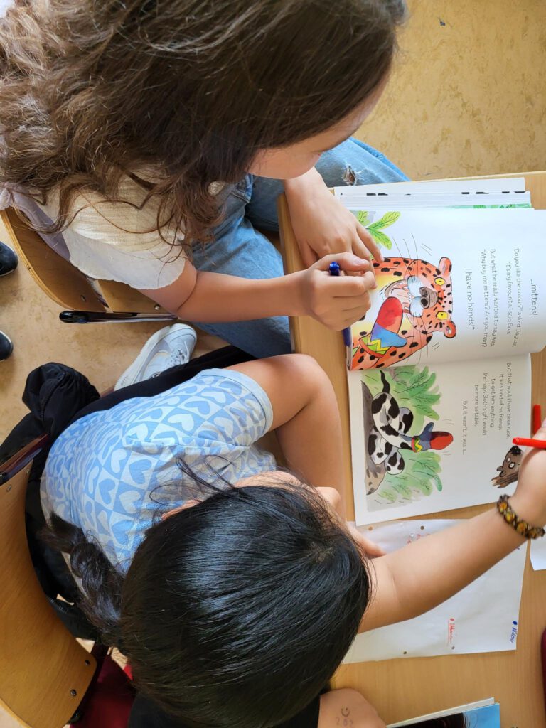 Zwei Kinder lesen ein Buch auf Englisch