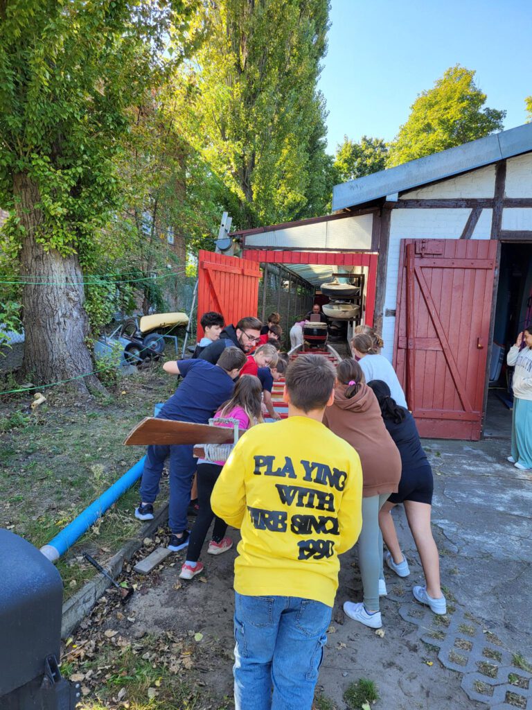 Kinder Klasse 5b helfen beim Drachenboot holen