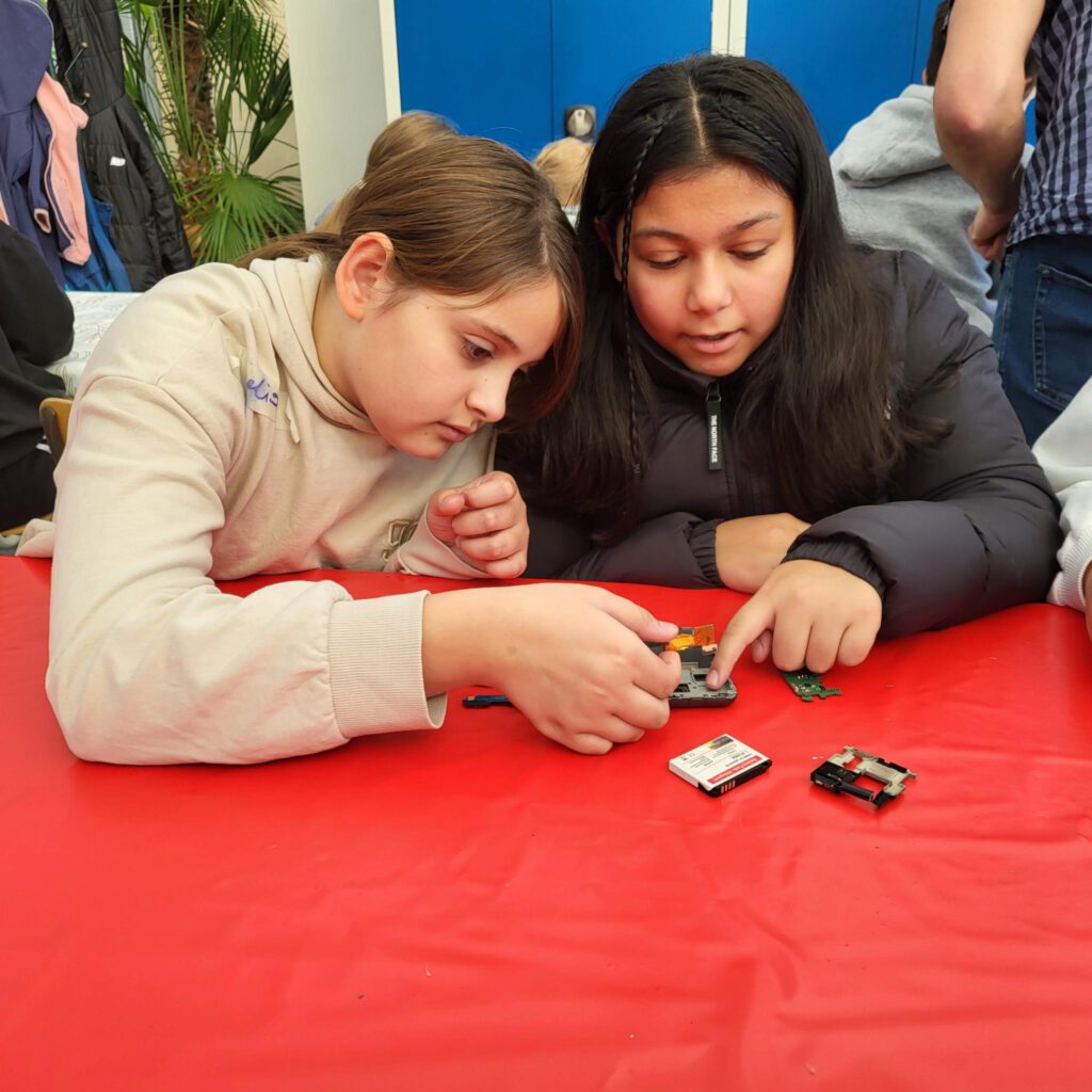 Zwei Kinder bauen ein Handy auseinader