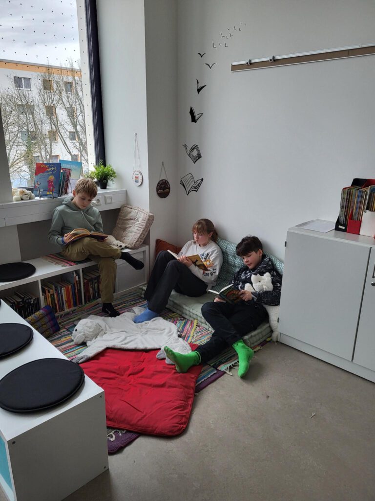 3 Kinder lesen in einer Leseecke