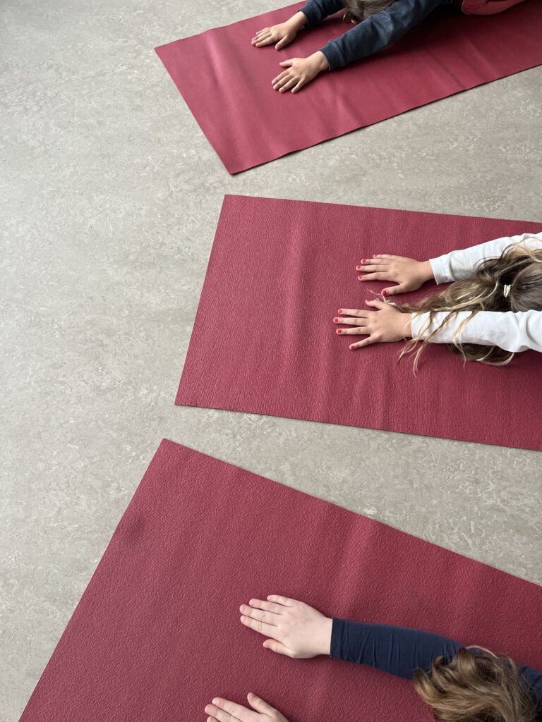 Kinderhände auf der Yogamatte