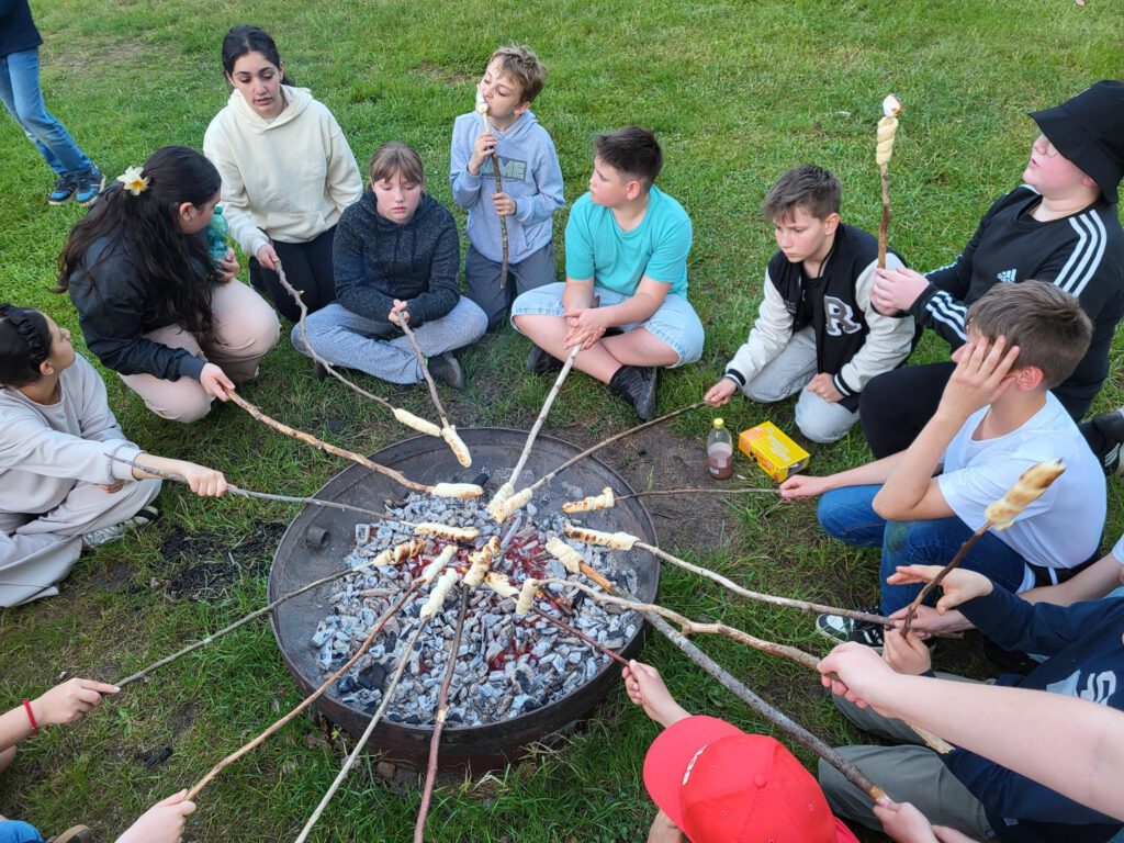 Kinder mit Stockbrot am Lagerfeuer