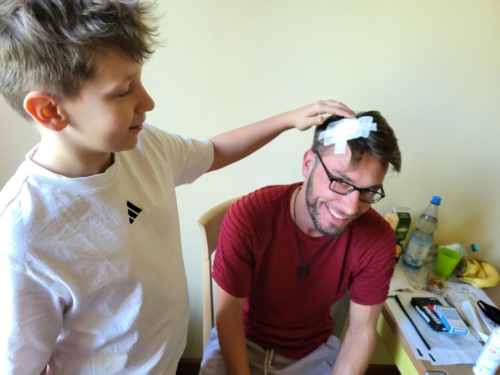 Kind verarztet einen Lehrer