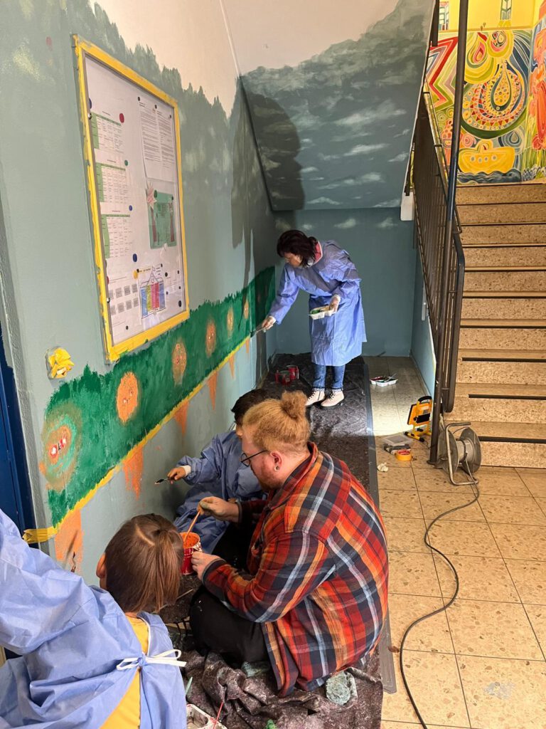 Kinder und Erzieher bemalen den Flur