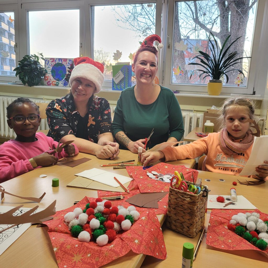 Kinder basteln mit Erziehern im Klassenraum