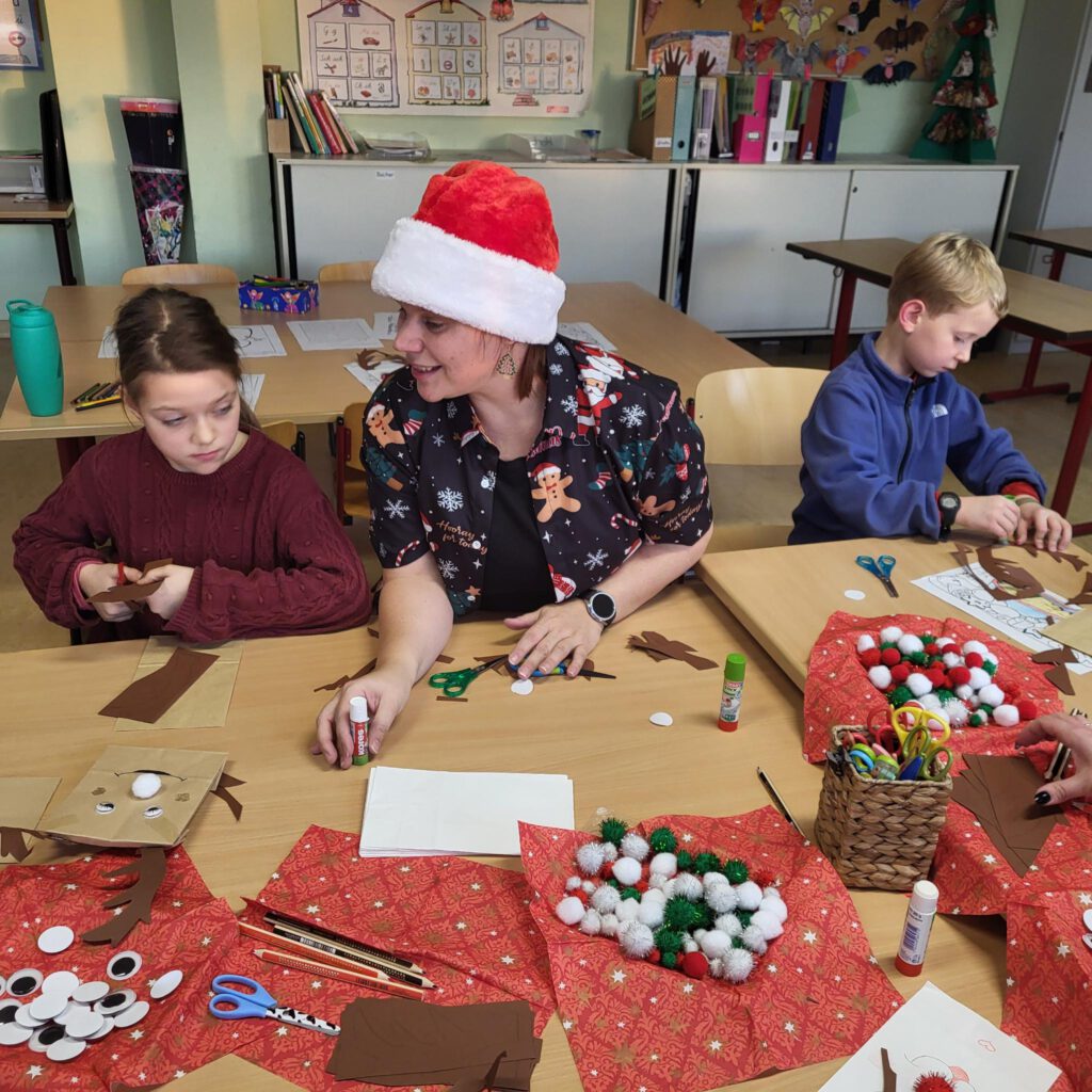 Kinder basteln mit Erzieher im Klassenraum