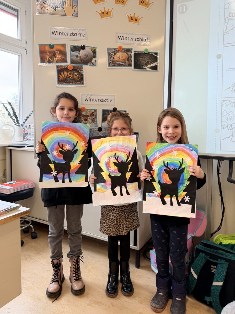 Kinder halten ihre Zeichnung hoch von Wintertieren