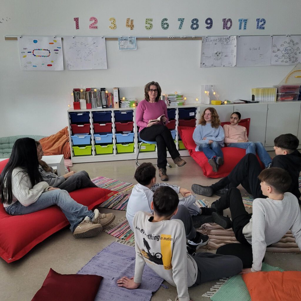 Lehrerin liest der Klasse etwas vor. 