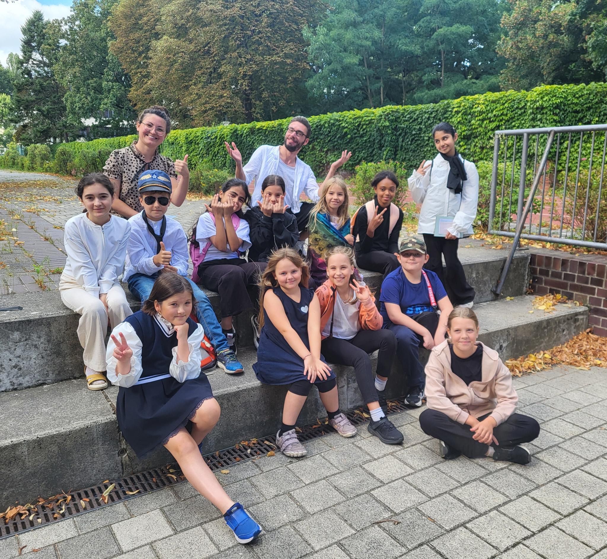 Kinder der 5. Klasse winken in die Kamera